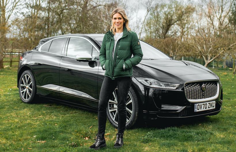 Nicki Shields standing in front of a black Jaguar I-Pace electric car.